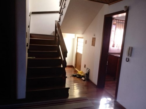 Ambiente entre sala e cozinha, com acesso ao 2° piso.